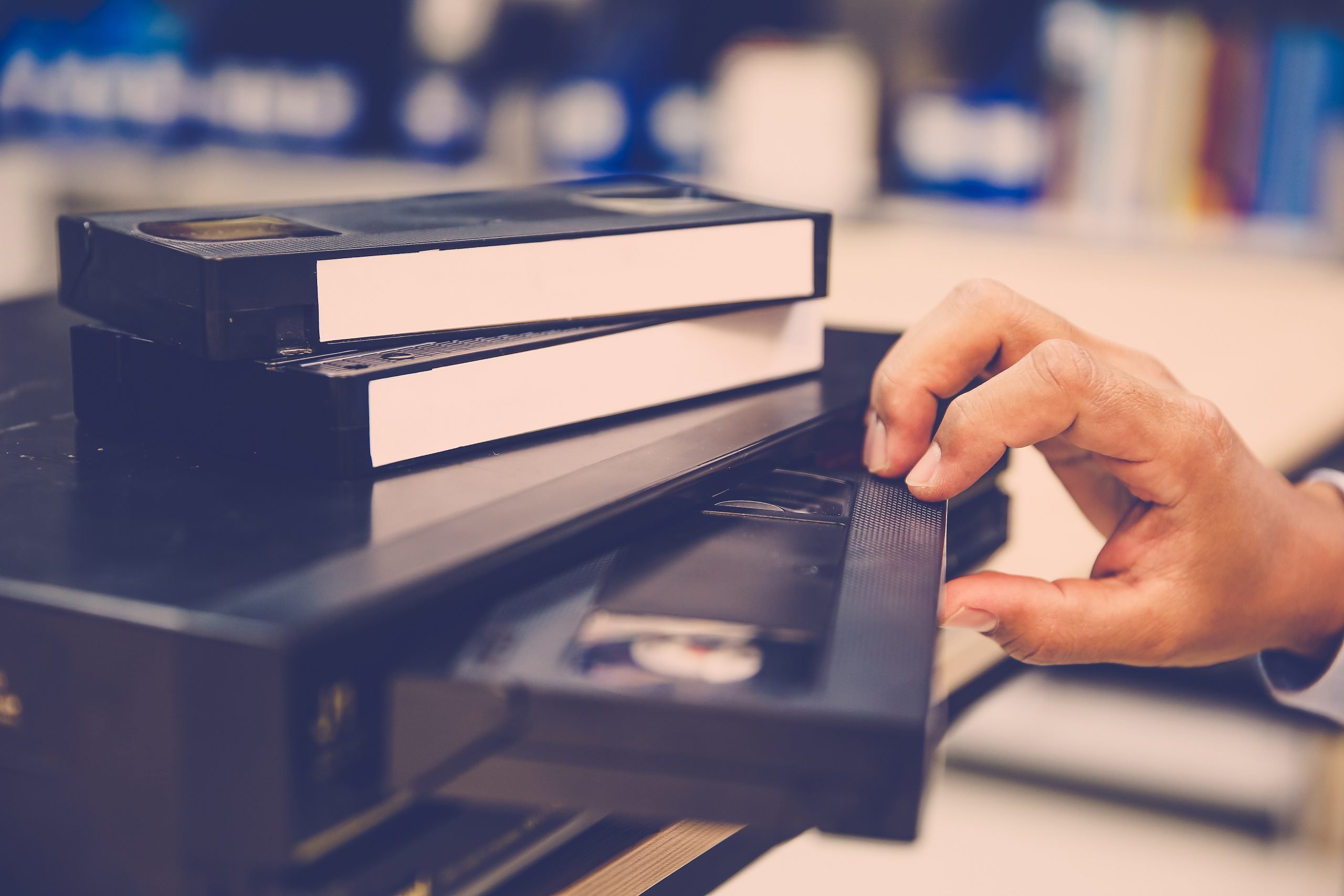 Close-up hand put or insert video cassette tape VHS old retro style on video record playback concept of vintage electric and electronic appliances multimedia player device old fashioned.